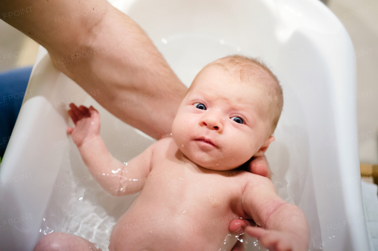 Close up of unrecognizable young father bathing his little baby son