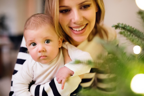 Beautiful young mother holding her cute baby son in the arms