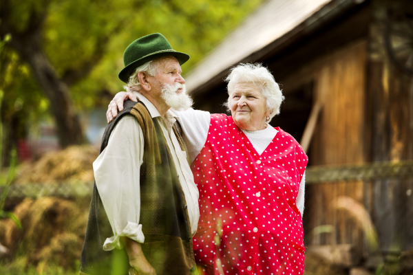 Old couple of seniors in the garden, sunny day.