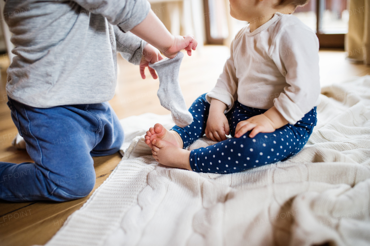 Two unrecognizable toddler children playing at home.