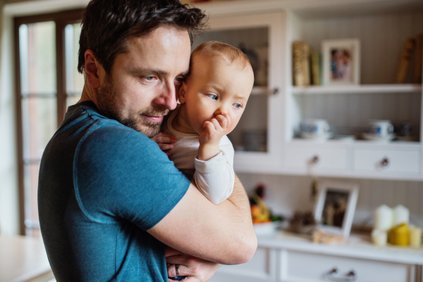 Father with a baby girl at home. Paternity leave.