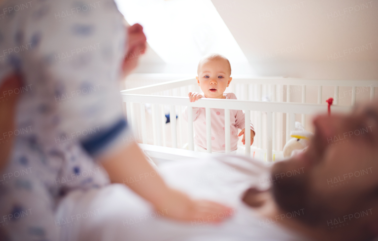 Unrecognizable father with toddler children in bedroom at home at bedtime. Paternity leave.