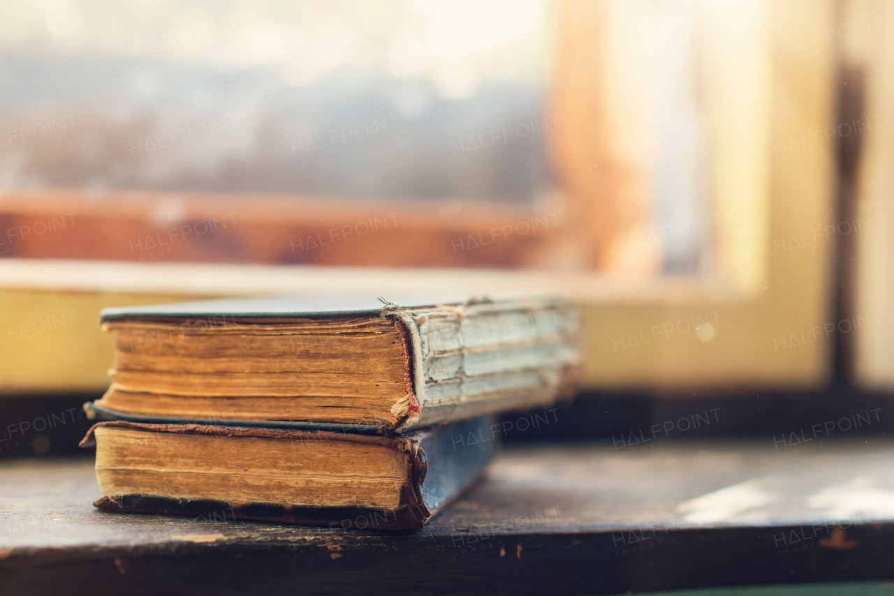 Stack of old books laid on windowsill