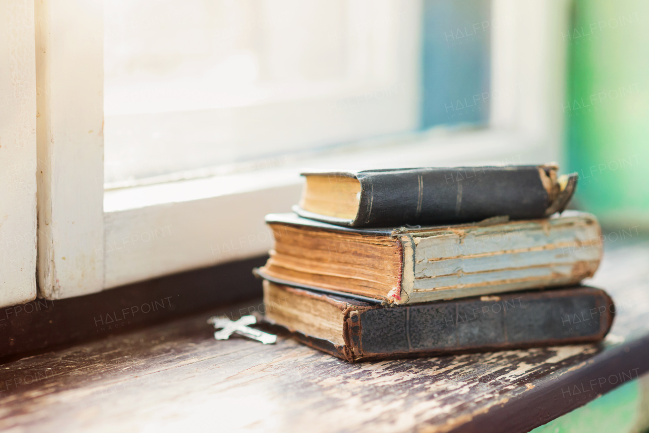 Stack of old books laid on windowsill