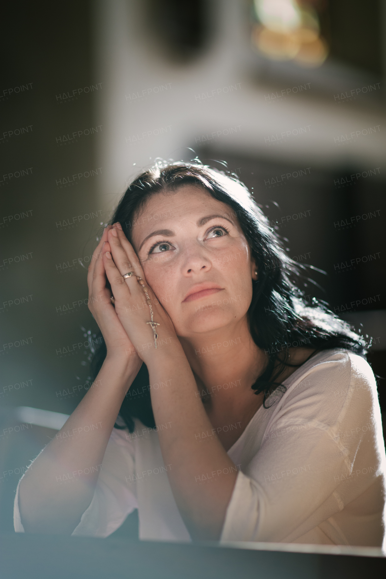 Beautiful woman with a rosary praying in the church