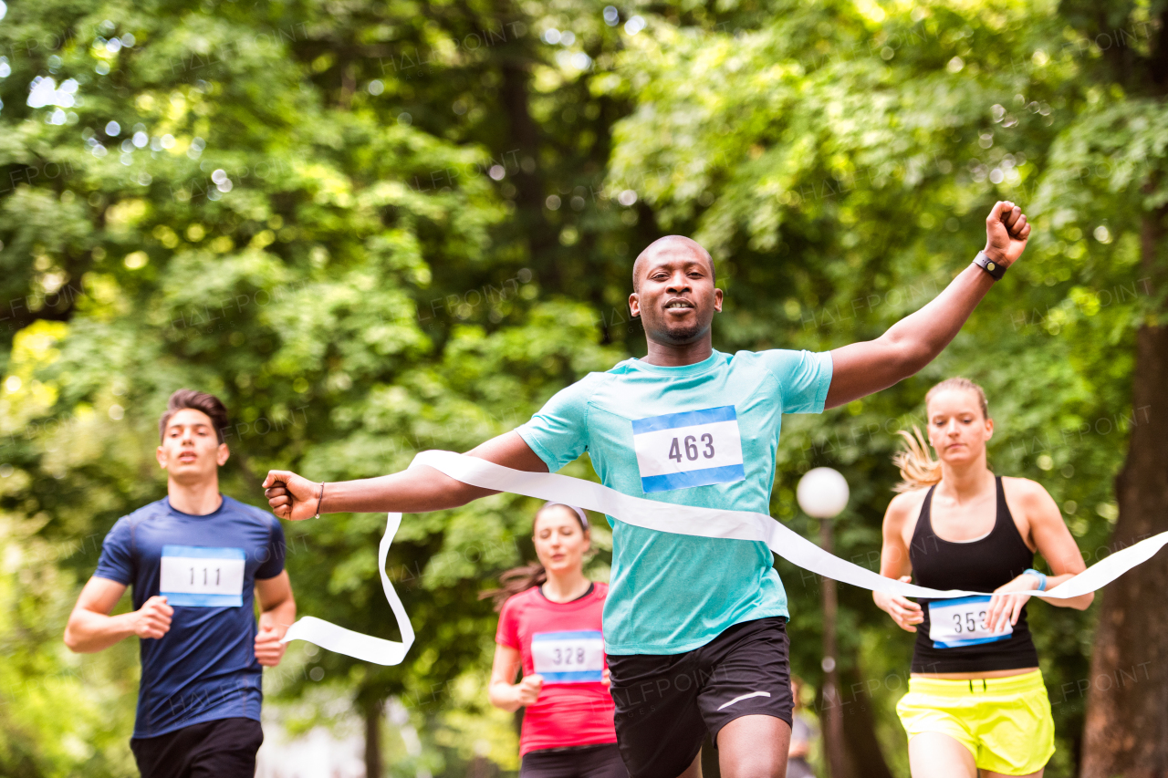 African man running in the crowd crossing the finish line.