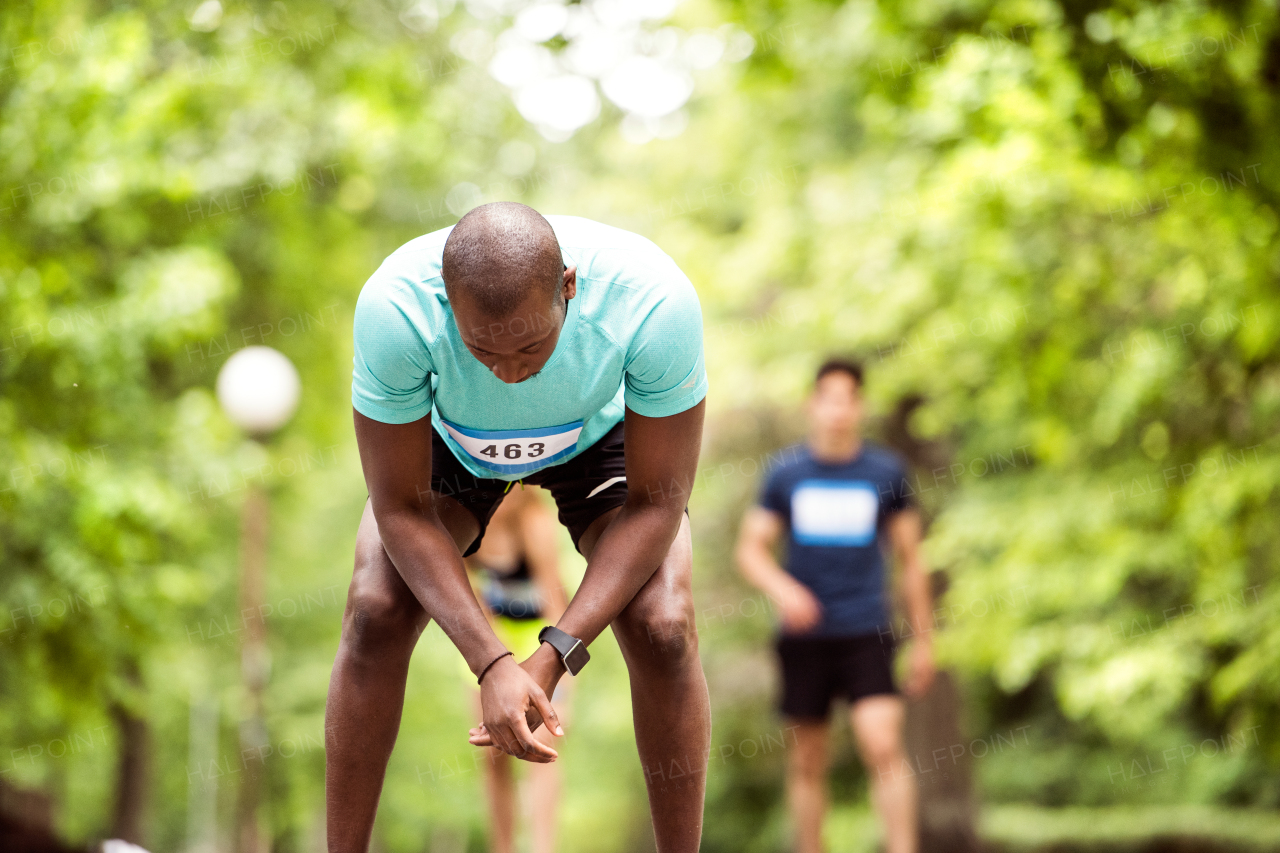 Young fit afro-american man in park resting after finishing race.