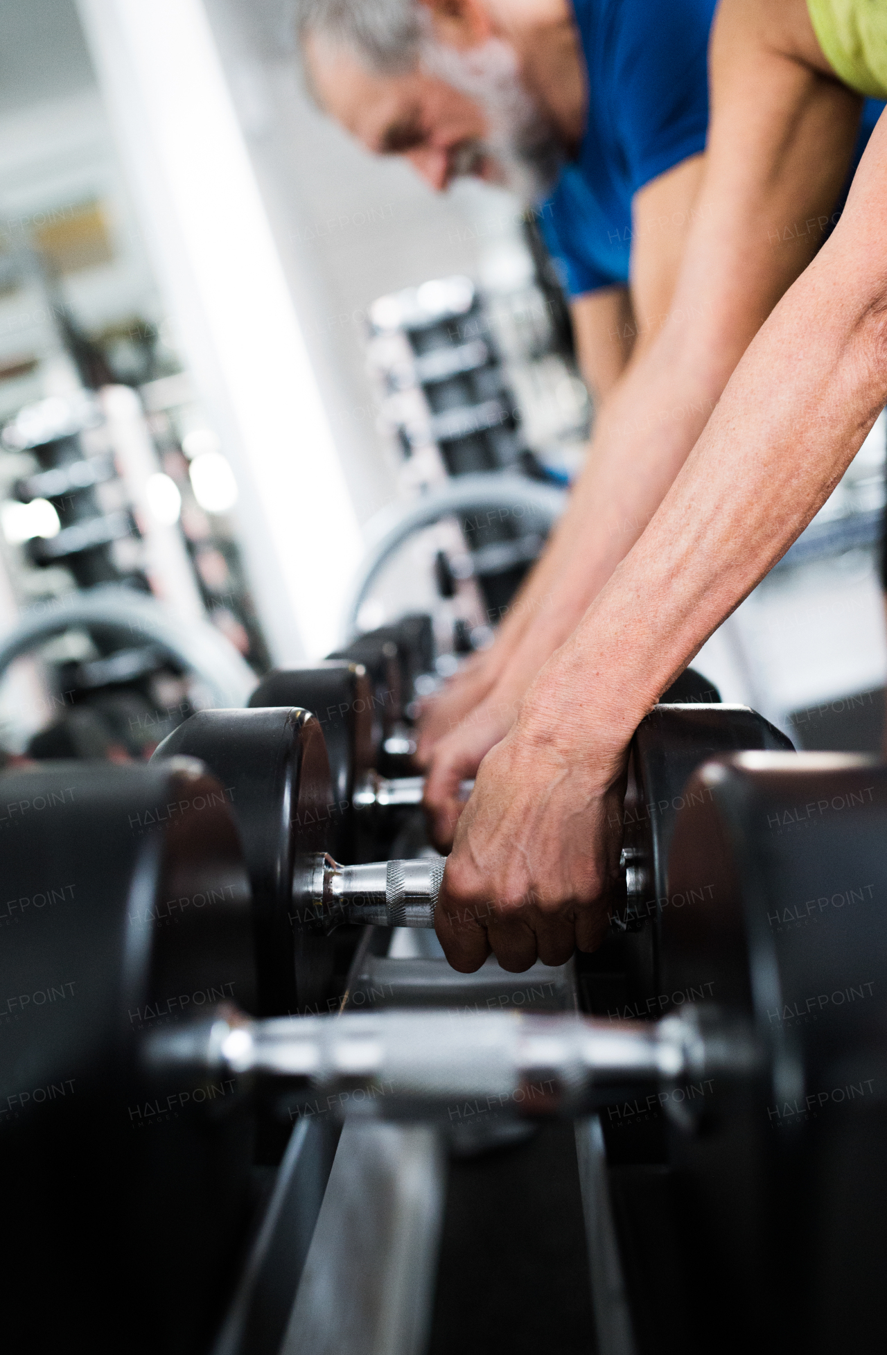 Close up of hands of senior couple in gym that is going to work out with weights