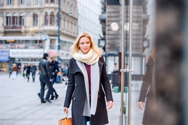 Beautiful young woman window shopping in historical centre of the city of Vienna, Austria. Winter.