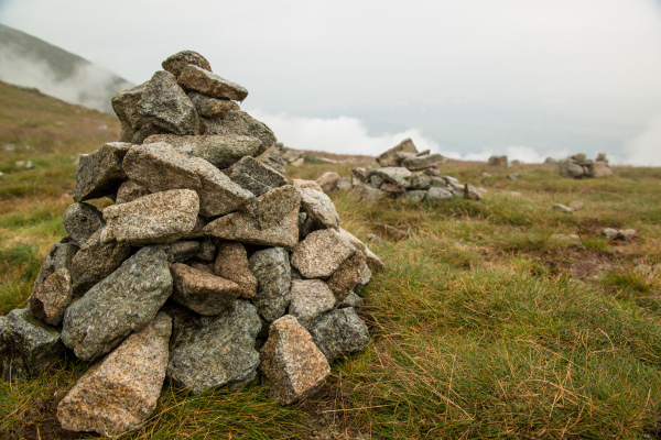 Stacks of rocks stones with cloudy mountains after rain, rainy misty day, High Tatras Slovakia. Beautiful mountain landscape.