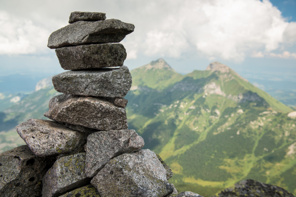 Stack of rocks stones with cloudy mountains after rain, rainy misty day, High Tatras, Slovakia. Beautiful mountain landscape.