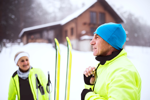 Active senior couple getting ready for cross-country skiing. Winter time.