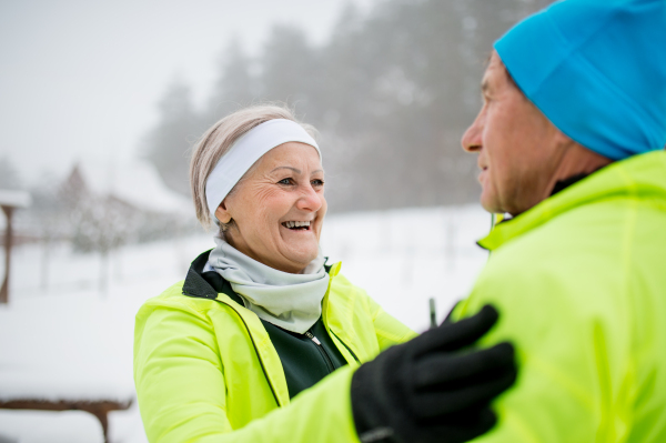 Active senior couple getting ready for cross-country skiing. Winter time.