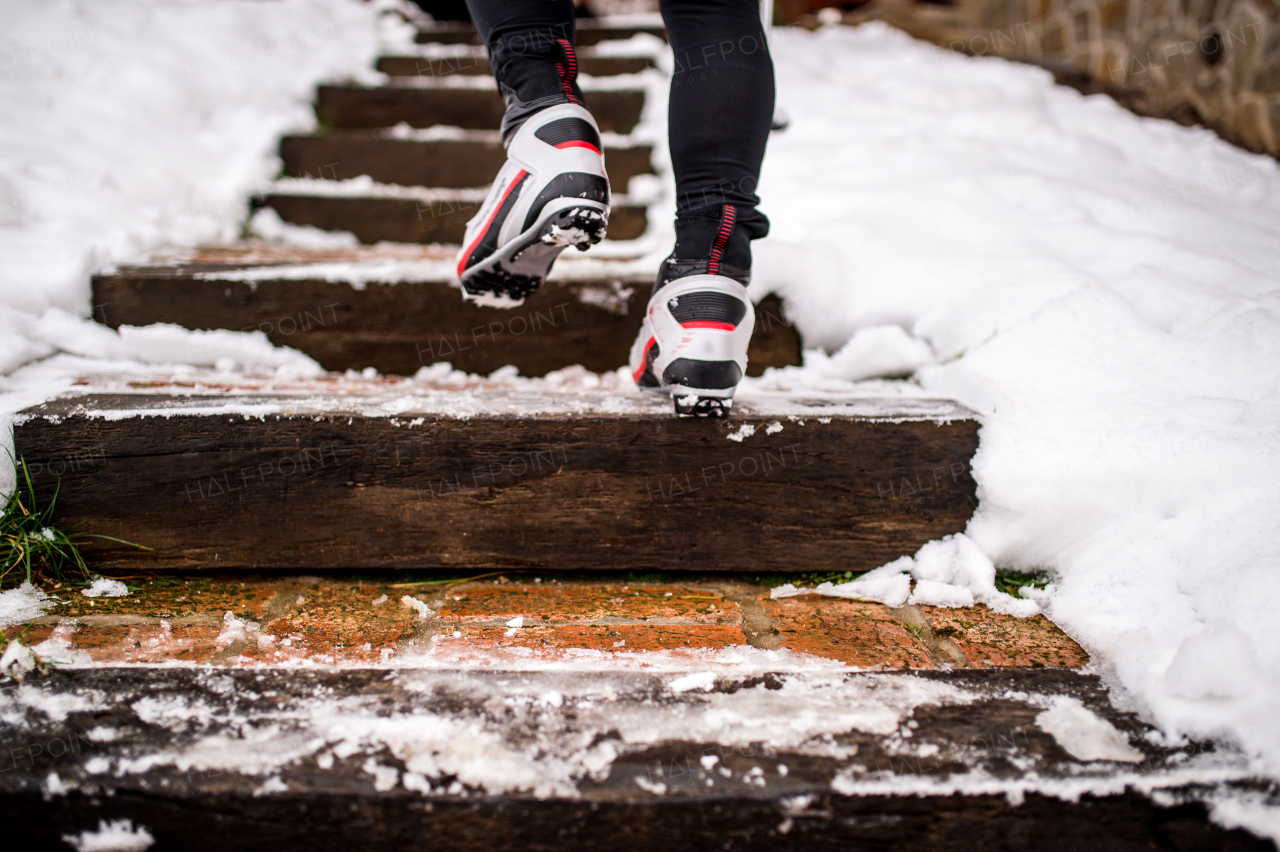 Feet of unrecognizable cross-country skier, walking up the stairs. Winter time.