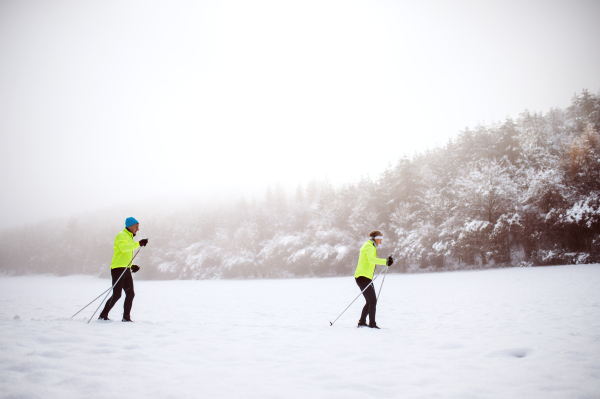 Active senior couple cross-country skiing. Winter time.