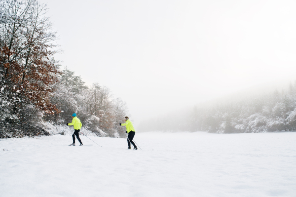 Active senior couple cross-country skiing. Winter time.