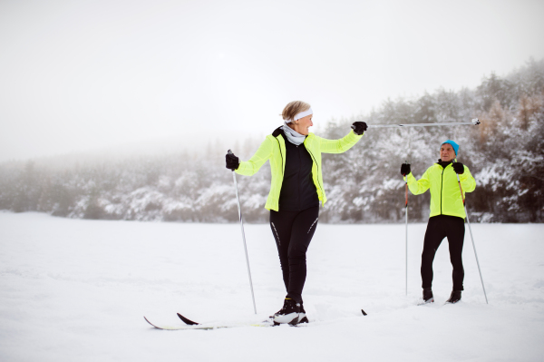 Active senior couple cross-country skiing. Winter time.