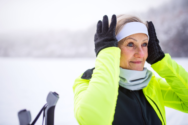 Active senior woman getting ready for skiing. Winter time.