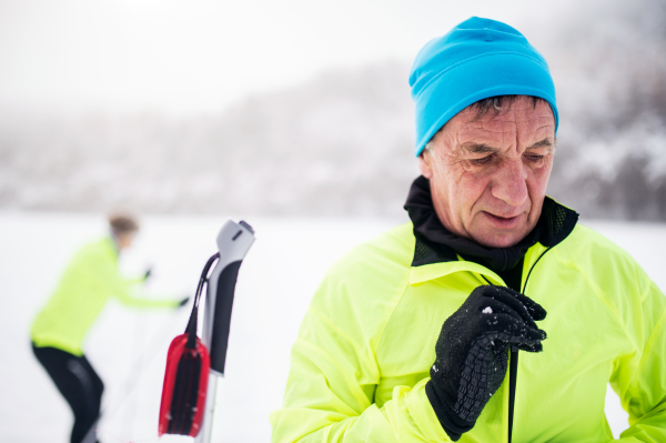 Active senior couple cross-country skiing. Winter time.