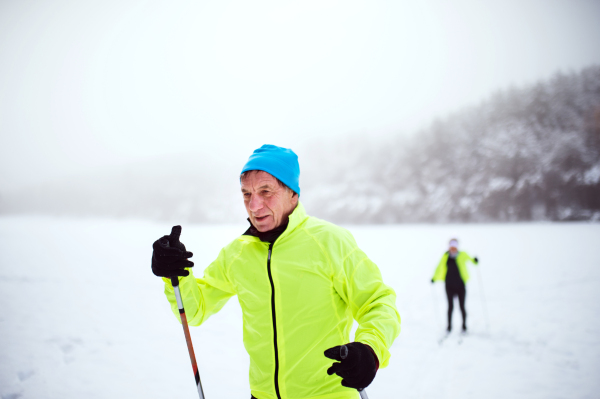 Active senior couple cross-country skiing. Winter time.