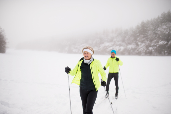 Active senior couple cross-country skiing. Winter time.