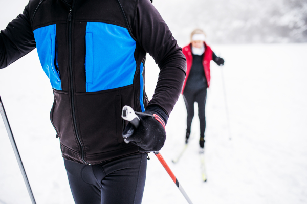 Unrecognizable active senior couple cross-country skiing. Winter time.