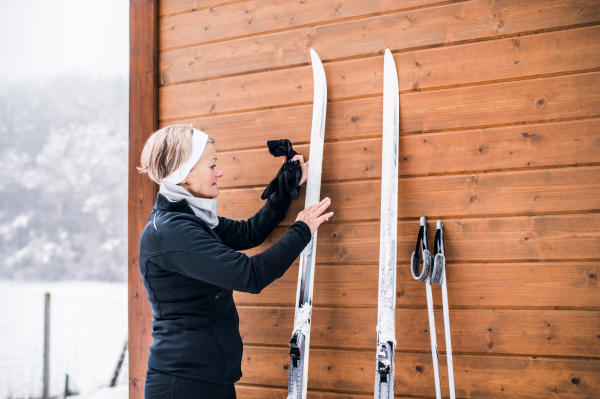 Active senior woman getting ready for skiing. Winter time.