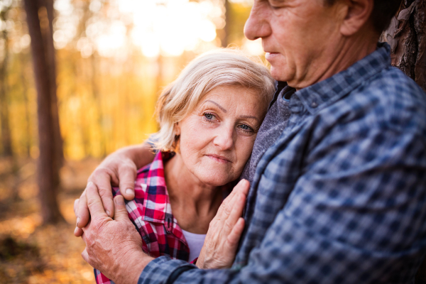 Active senior couple on a walk in a beautiful autumn forest. Close up.