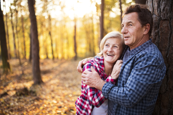 Active senior couple on a walk in a beautiful autumn forest.