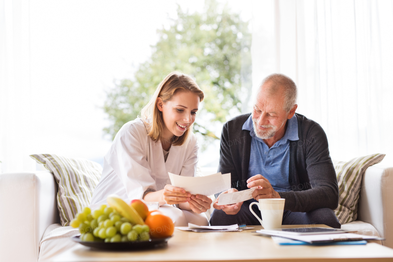 Health visitor and a senior man during home visit. A female nurse or a doctor discussing test results.