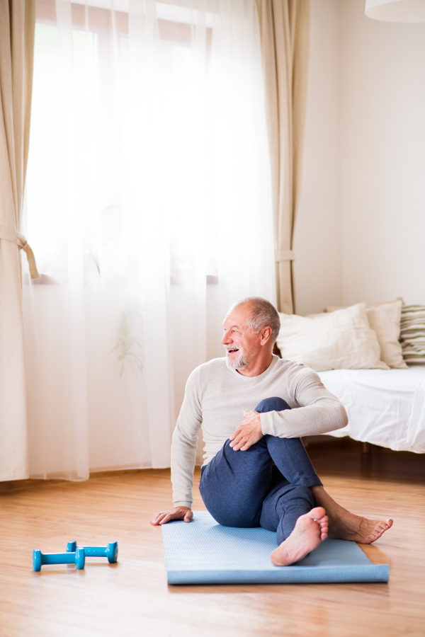 Active senior man doing exercise at home.