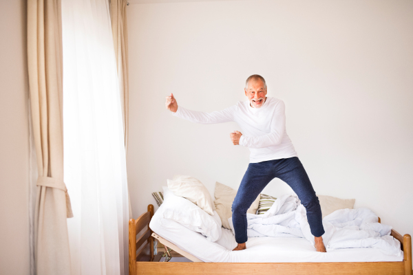 Active senior man doing exercise at home. Man sta