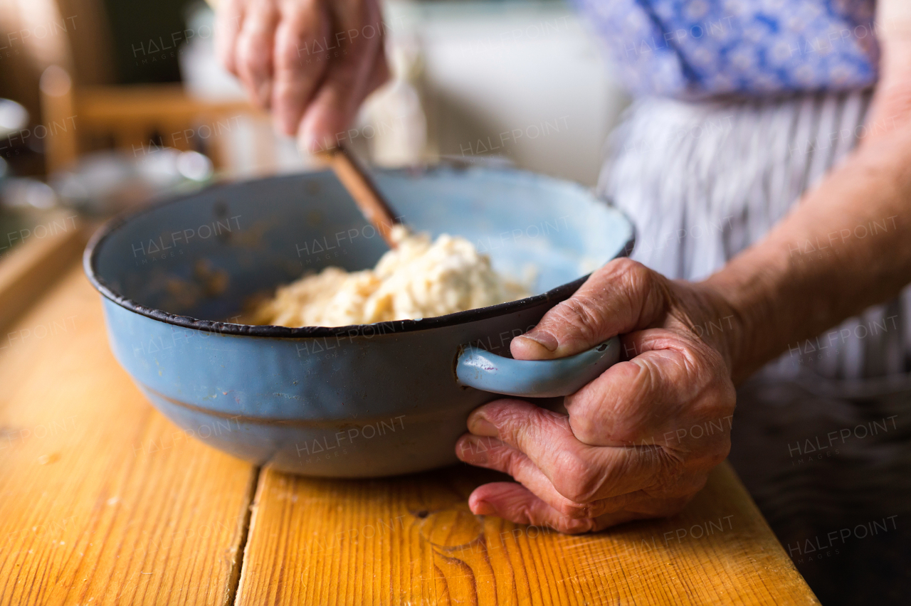 Senior woman baking pies in her home kitchen.  Mixing ingredients.