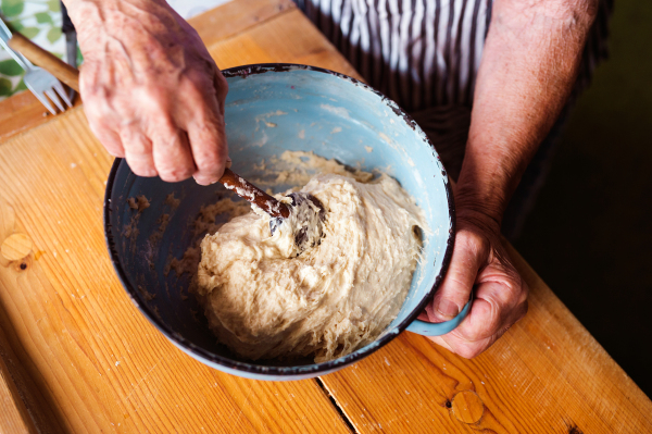 Senior woman baking pies in her home kitchen.  Kneading dough.