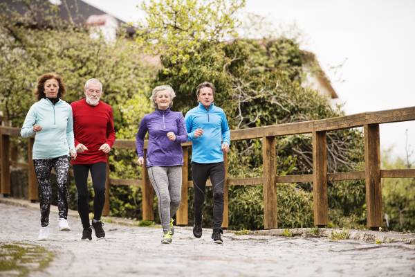 Group of active seniors running together outdoors in the old town of Banska Stiavnica in Slovakia.