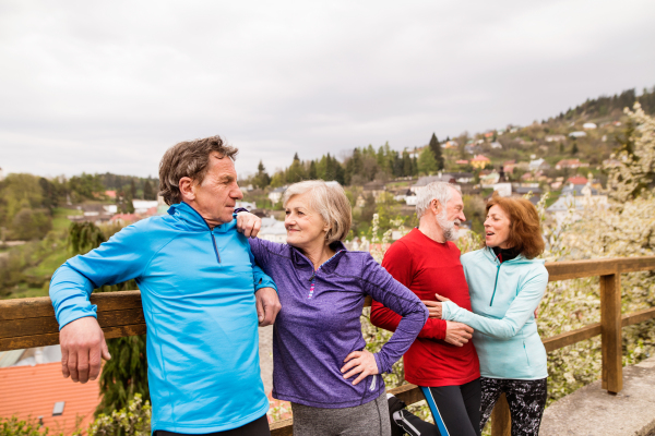 Group of active senior runners posing together outdoors in the old town of Banska Stiavnica in Slovakia.