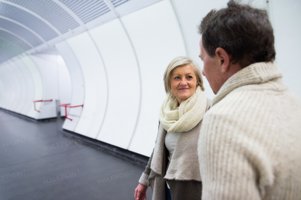 Beautiful senior couple in winter clothes in the hallway of subway in Vienna