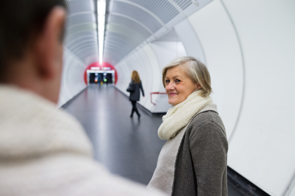 Beautiful senior couple in the hallway of subway in Vienna saying goodbye.