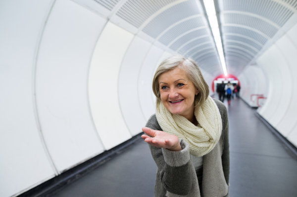 Beautiful senior woman in hallway of subway in Vienna saying goodbye, sending someone a kiss.