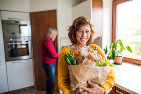 Senior couple preparing food in the kitchen. An old man and woman inside the house.