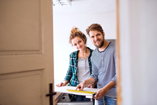 Small business of a young couple. Man and woman worker in the carpenter workroom.