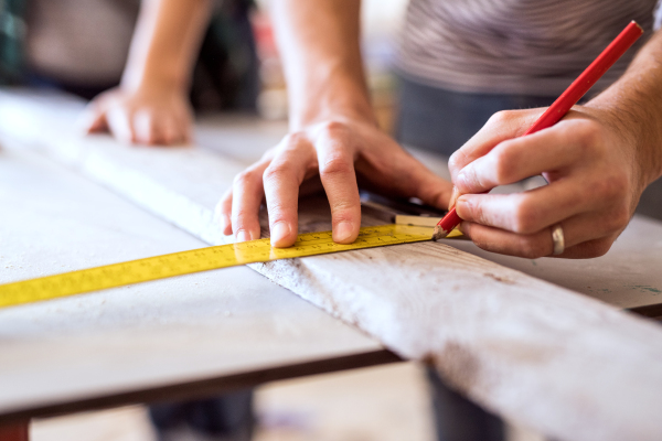 Small business of a young couple. Unrecognizable man and woman worker in the carpenter workroom.