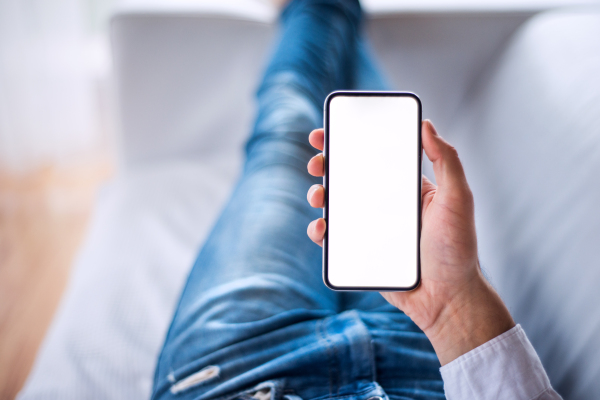 A mockup image of a man holding smartphone with blank white screen. Smart home control system.