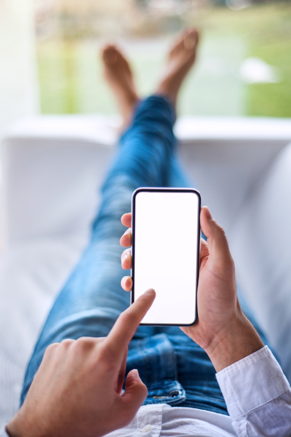 A mockup image of a man holding smartphone with blank white screen. Smart home control system.