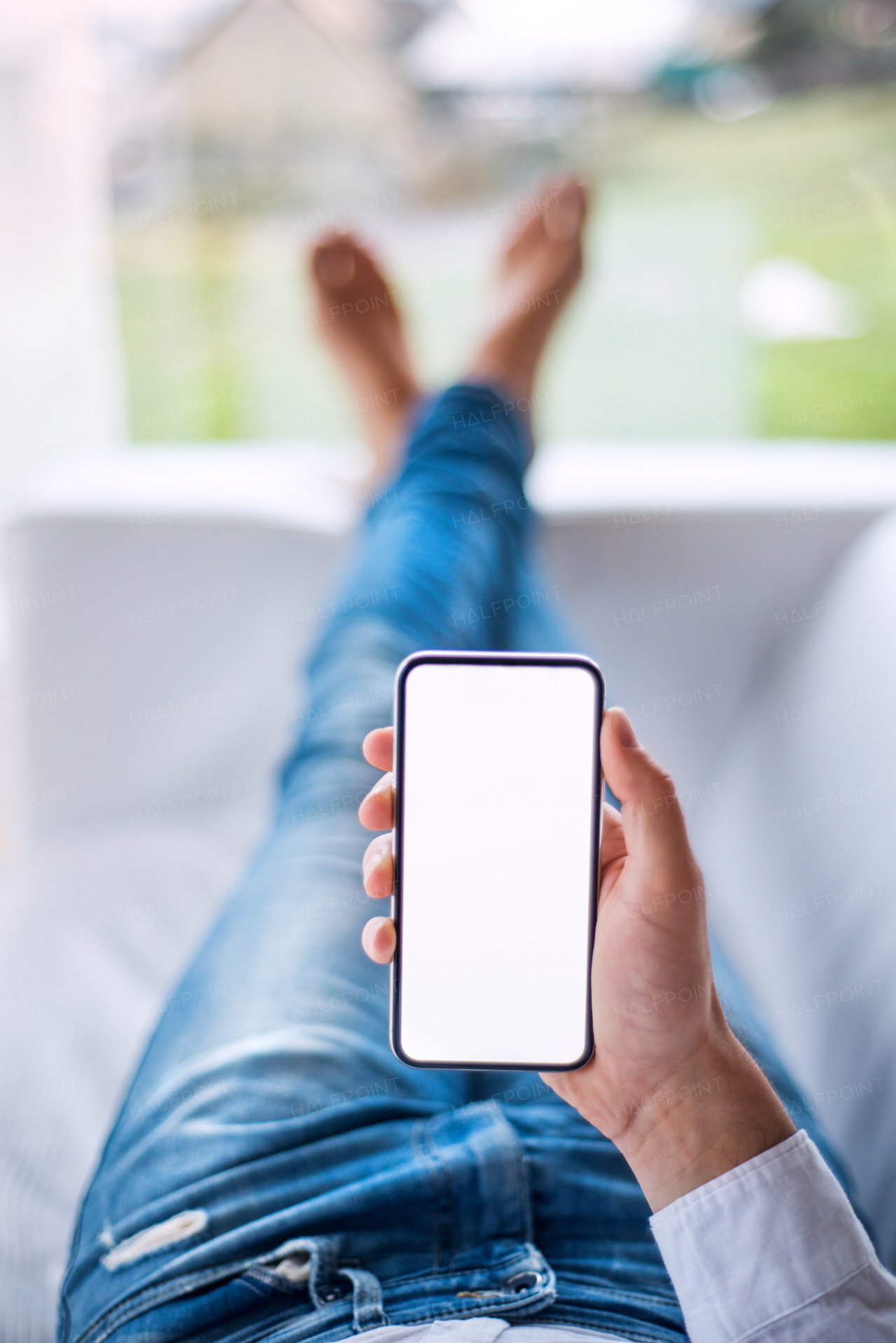 A mockup image of a man holding smartphone with blank white screen. Smart home control system.