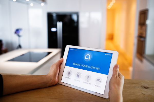 Male hands holding a tablet with smart home control system.