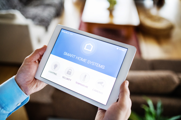 Male hands holding a tablet with smart home control system.