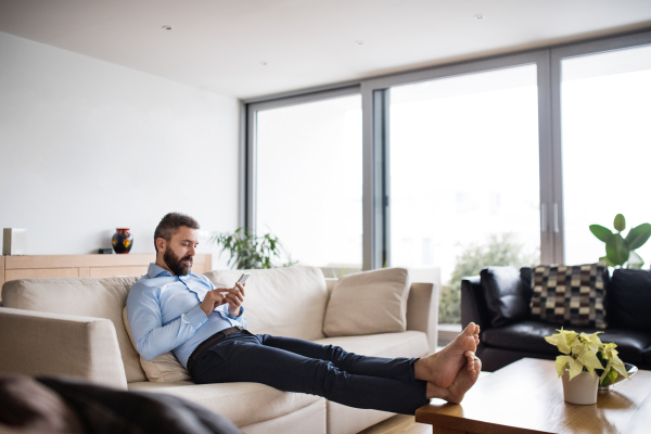 A man holding a smartphone. Smart home control system.