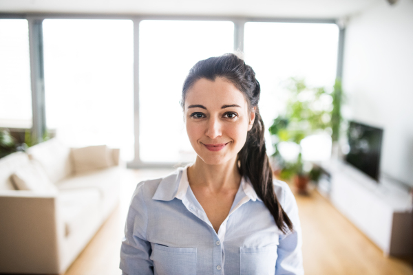 A portrait of a beautiful woman standing at home.