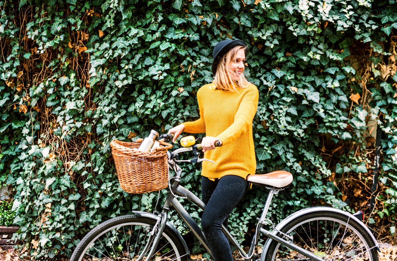 Young beautiful woman with bicycle in sunny spring nature.